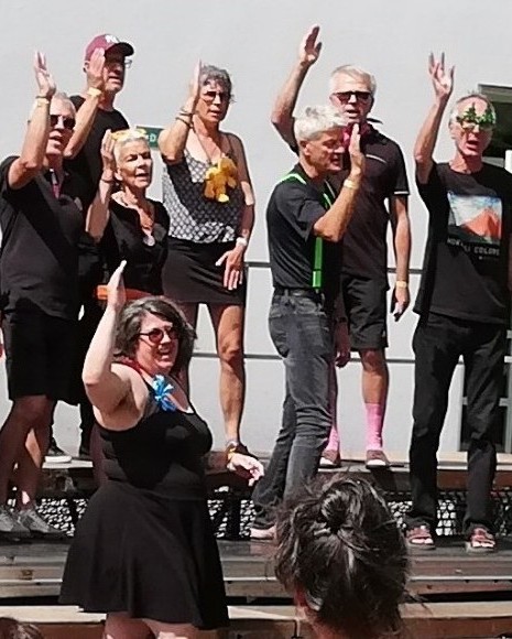 Des choristes saluent de la main